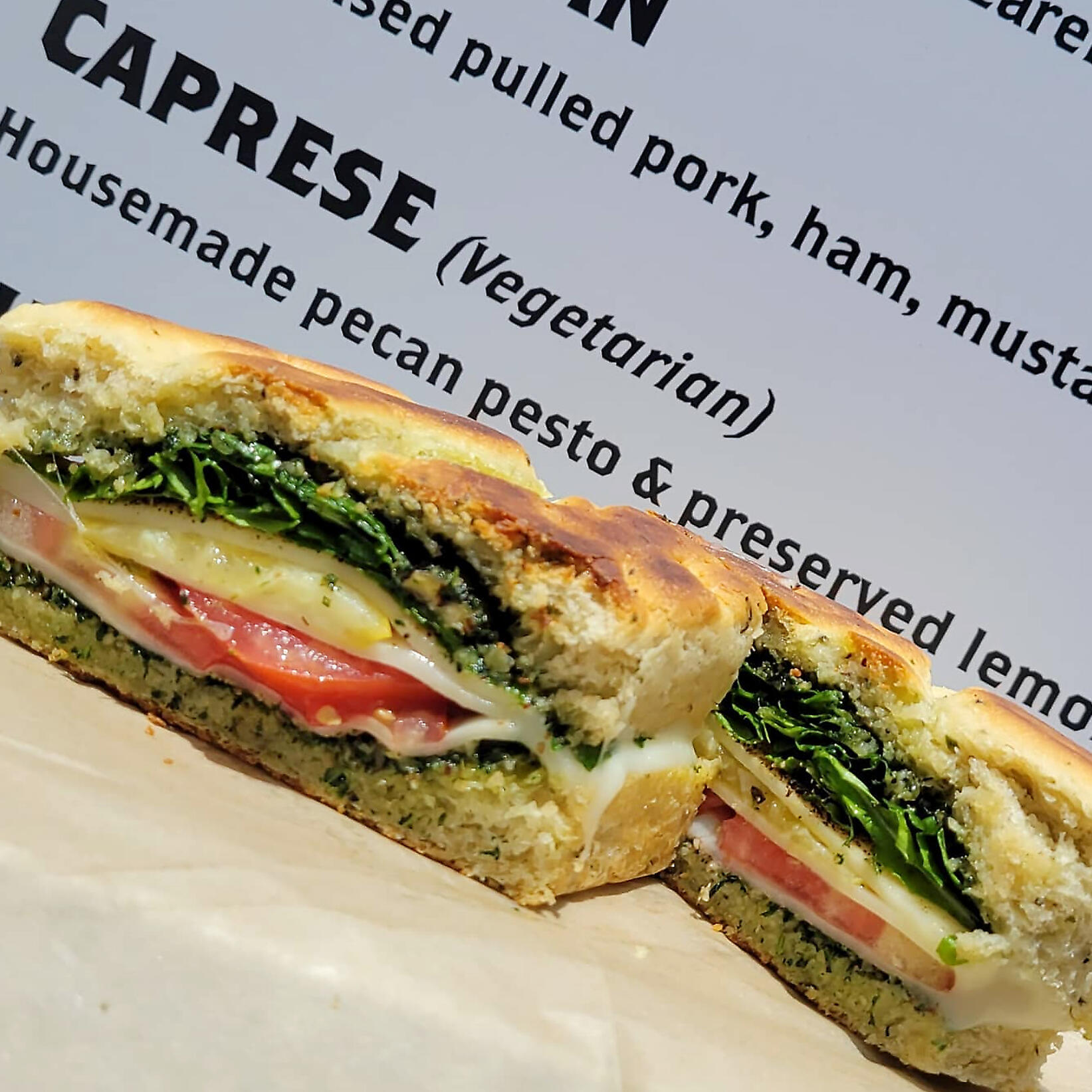 The Staple Sandwich Caprese, a vegetarian option on our staple menu with mozzarella, tomato, housemade pecan pesto and preserved lemon on our fresh baked focaccia.
